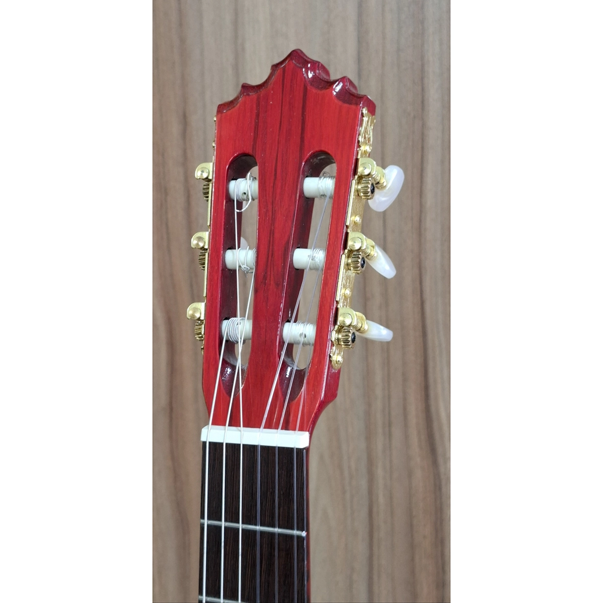 عکس کلوزآپ سر دسته گیتار سولا رنگ قرمز با ماشین‌سری طلایی و گوشی‌های سفید، مناسب معرفی کیفیت ساخت گیتار کلاسیک
