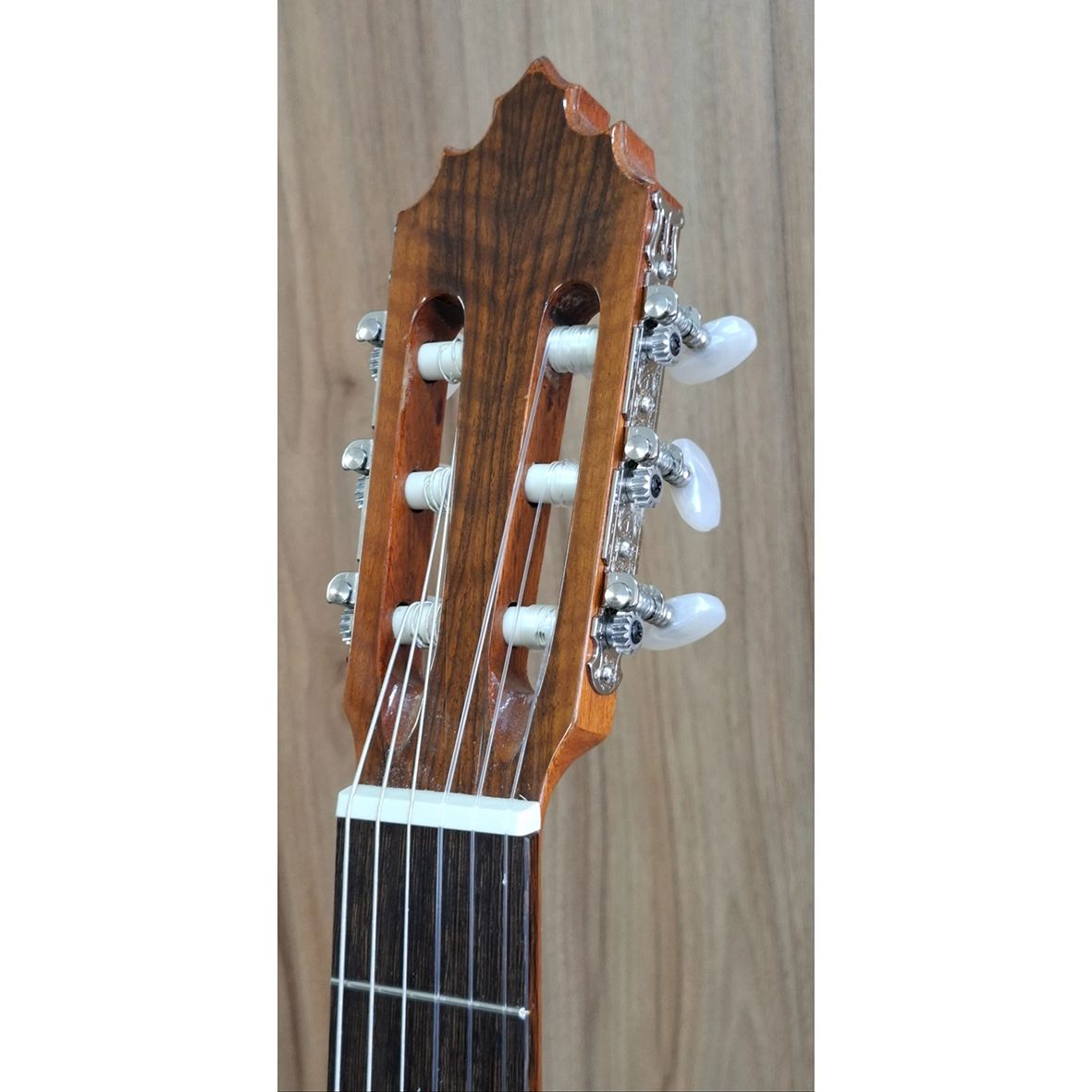 عکس کلوزآپ سر دسته گیتار سولا رنگ نارنجی با ماشین‌سری طلایی و گوشی‌های سفید، مناسب معرفی کیفیت ساخت گیتار کلاسیک
