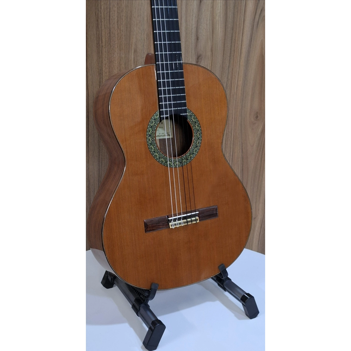 نمای زاویه‌دار جلوی گیتار کلاسیک الحمبرا مدل 5P روی پایه، با صفحه‌ی سدر طبیعی و بدنه‌ی چوب رز‌وود