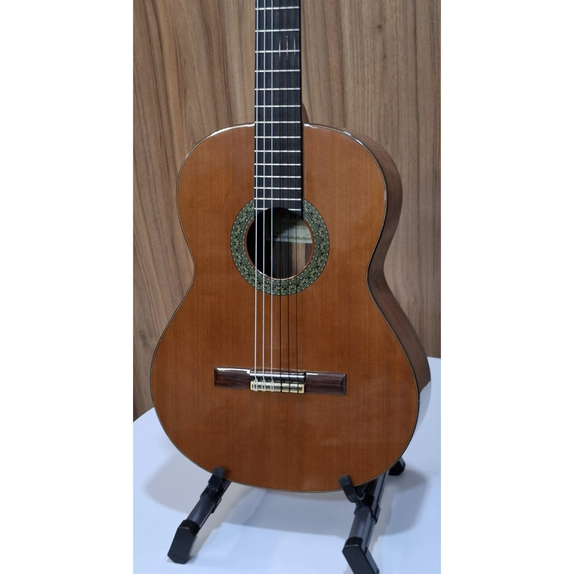 نمای زاویه‌دار جلوی گیتار کلاسیک الحمبرا مدل 5P روی پایه، با صفحه‌ی سدر طبیعی و بدنه‌ی چوب رز‌وود